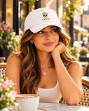 Woman wearing white King Eddie signature crest dad hat at an outdoor café