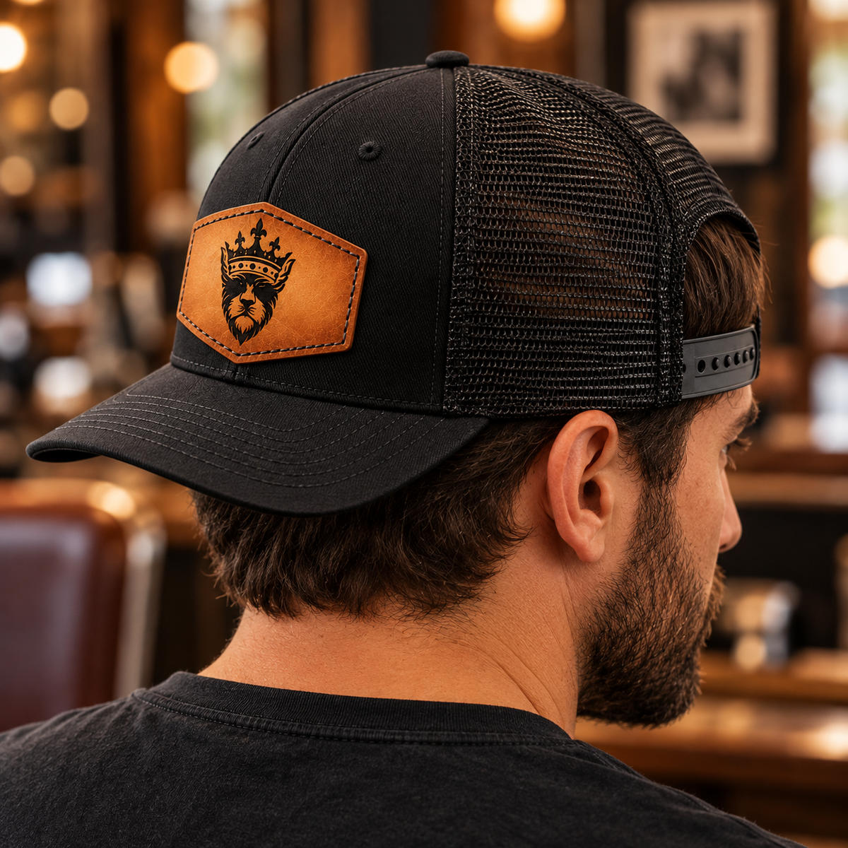 Black King Eddie Heritage Leather Patch Trucker Hat shown from a rear side angle, highlighting the mesh back, curved brim, and adjustable snapback fit.